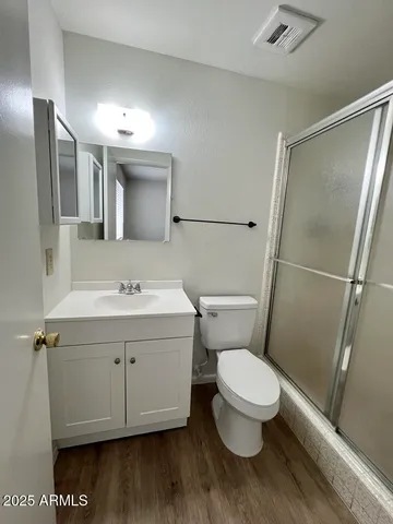 a bathroom with a sink a toilet and shower