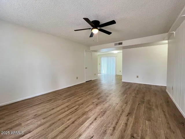 a view of empty room with wooden floor