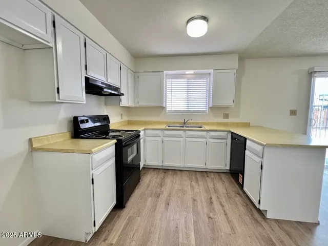 a kitchen with stainless steel appliances a white stove top oven sink and cabinets
