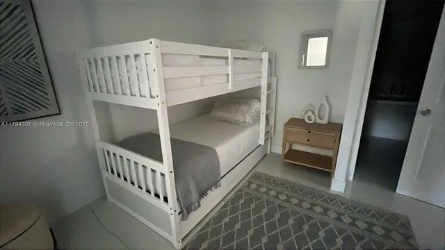 a view of bedroom with baby crib and deck
