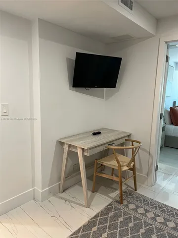 a room with a chair and a flat screen tv