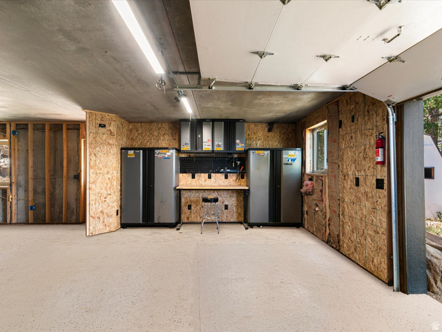 1225 Old Oregon Road Soda Springs, ID 83276 - Photo 50 of 67 Utility room featuring a concrete ceiling with linear lighting, unfinished OSB walls, built-in workbench, and epoxy flooring