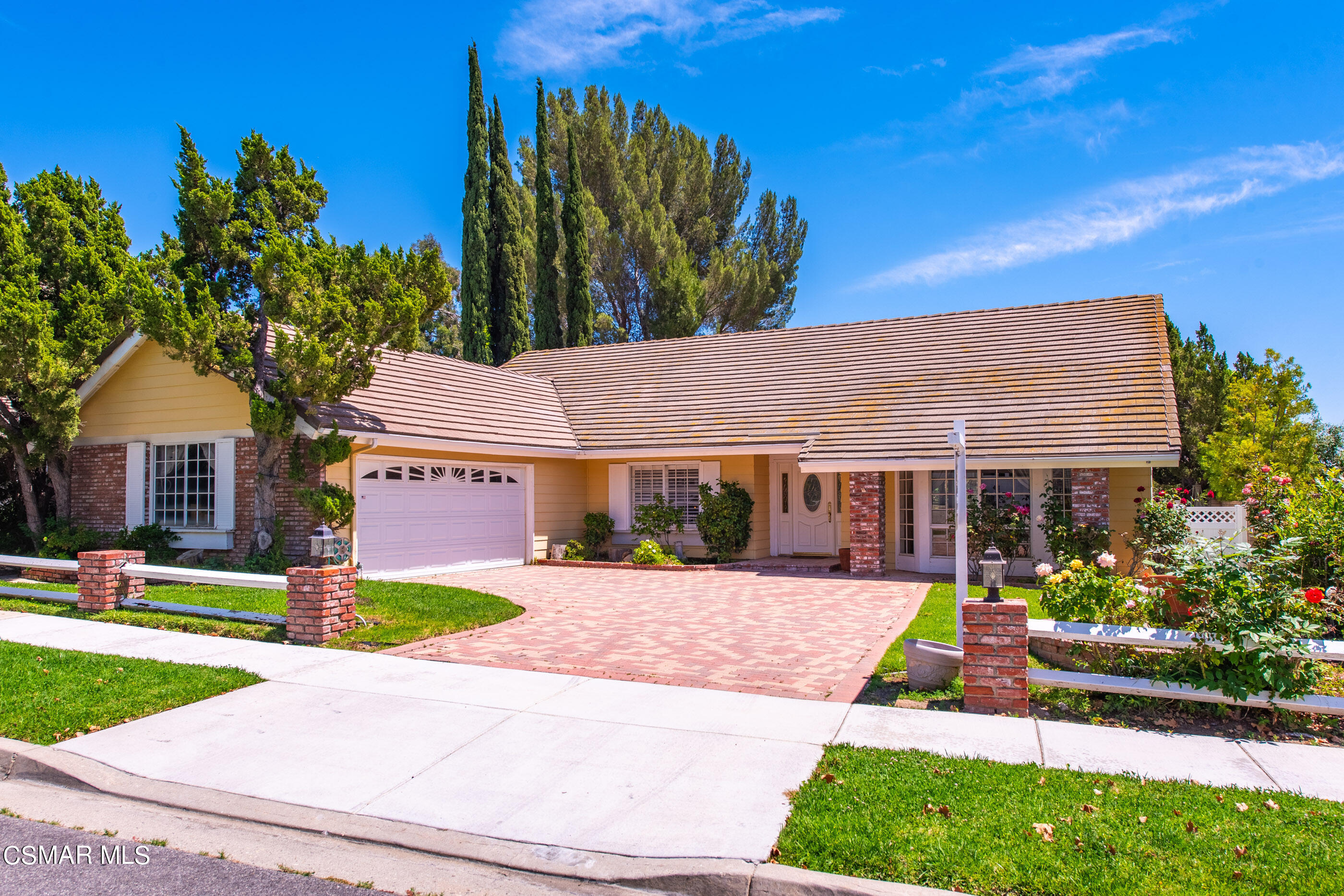 a front view of a house with a yard and potted plants