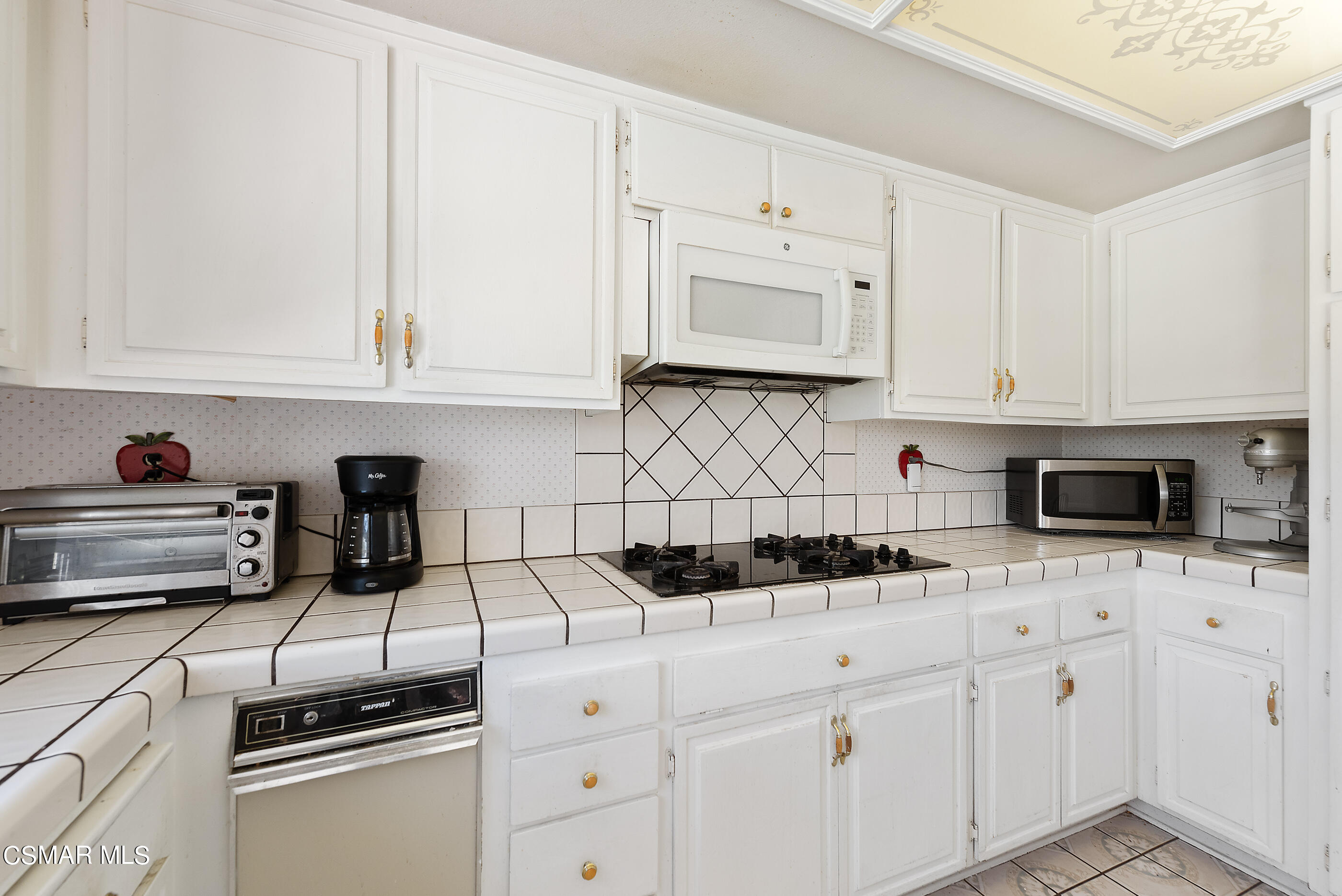 4230 Roxbury Street Simi Valley, CA 93063 - Photo 15 of 40 a kitchen with white cabinets and appliances