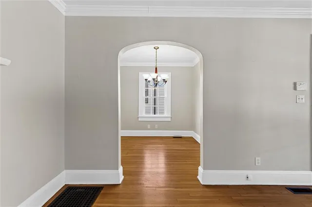 a view of a room with wooden floor and chandelier