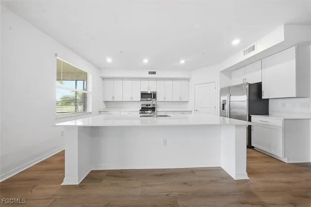 a kitchen with stainless steel appliances granite countertop a sink a stove a refrigerator and a oven