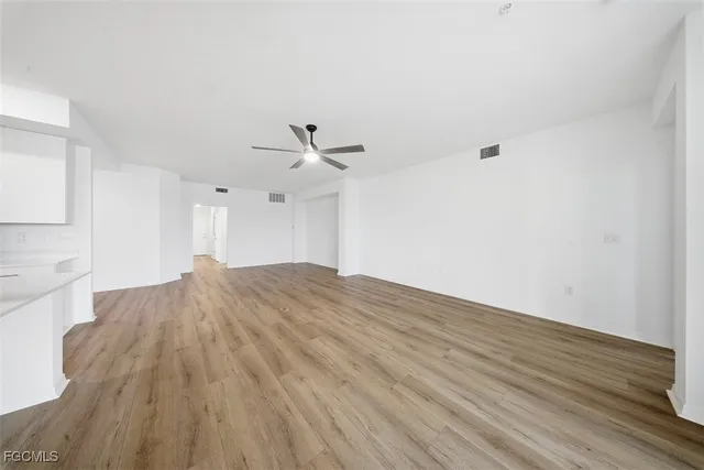 a view of empty room with wooden floor