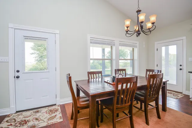 a view of a dining room with furniture a chandelier and wooden floor