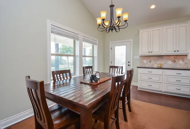 a view of a dining room with furniture a chandelier and wooden floor
