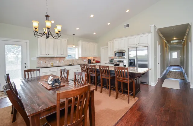a view of a dining room with furniture kitchen and chandelier