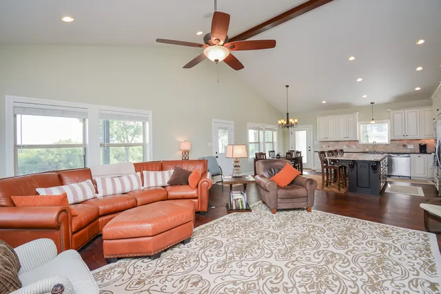 a living room with furniture kitchen view and a large window