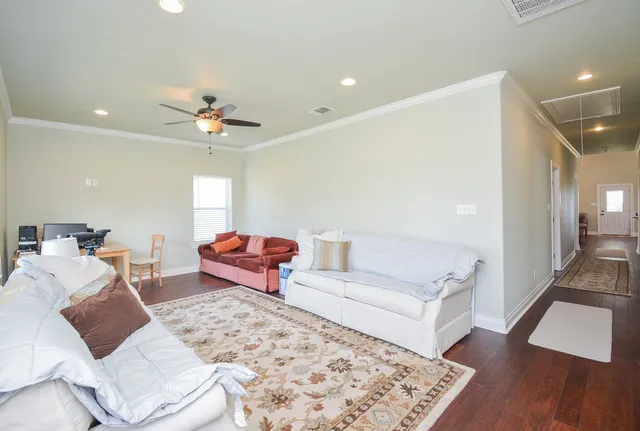 a living room with furniture and wooden floor