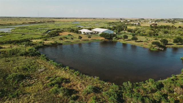 an aerial view of ocean and residential houses with outdoor space