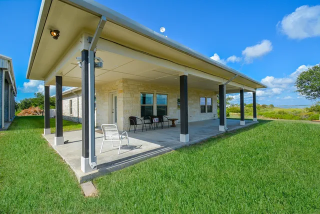 a view of a house with a backyard porch and sitting area