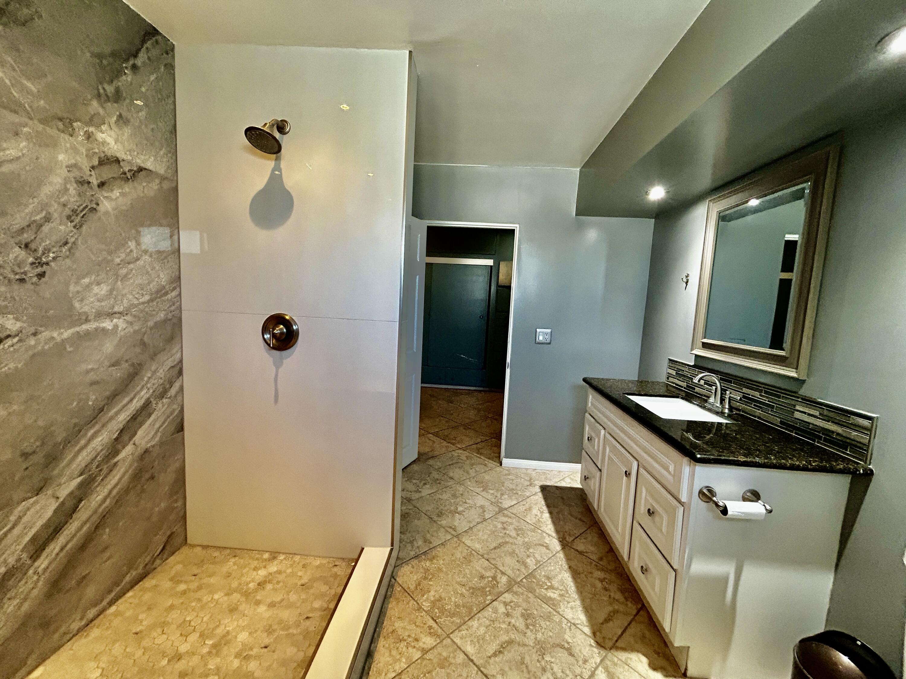54878 Harrison Street Thermal, CA 92274 - Photo 29 of 58 a bathroom with a granite countertop sink a mirror and shower