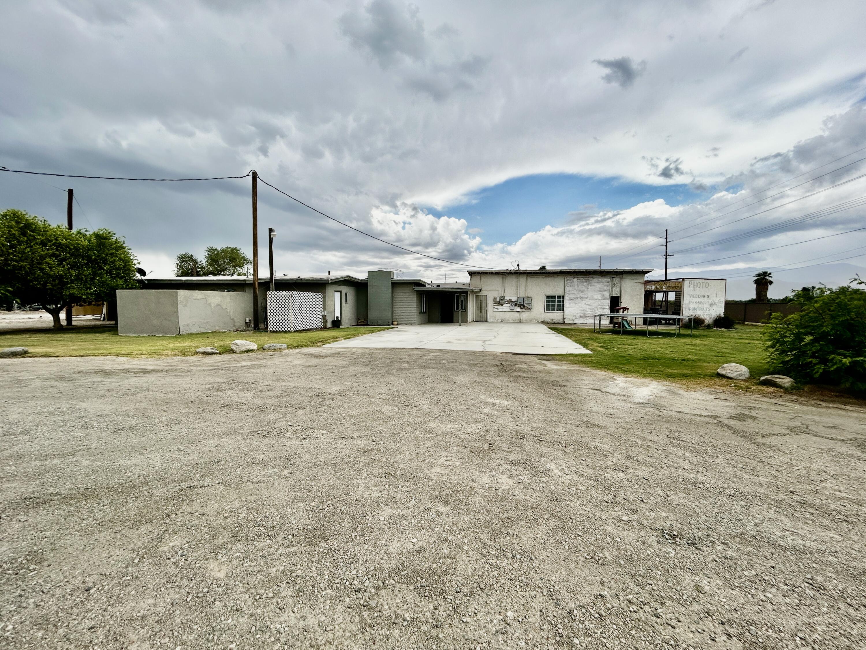 54878 Harrison Street Thermal, CA 92274 - Photo 54 of 58 a view of a house with swimming pool and a yard