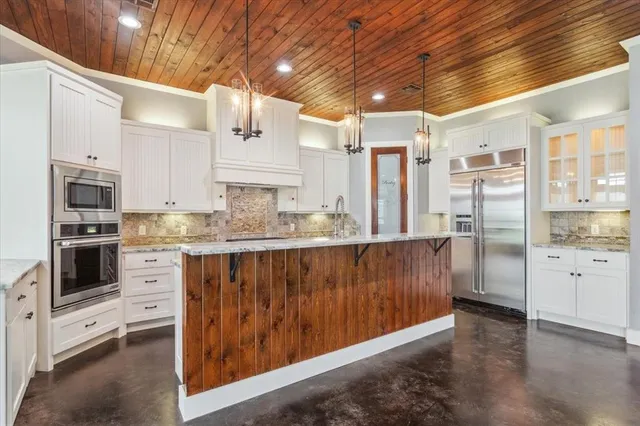 a kitchen with stainless steel appliances a refrigerator and a stove top oven