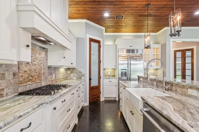 a large kitchen with kitchen island granite countertop a sink and cabinets