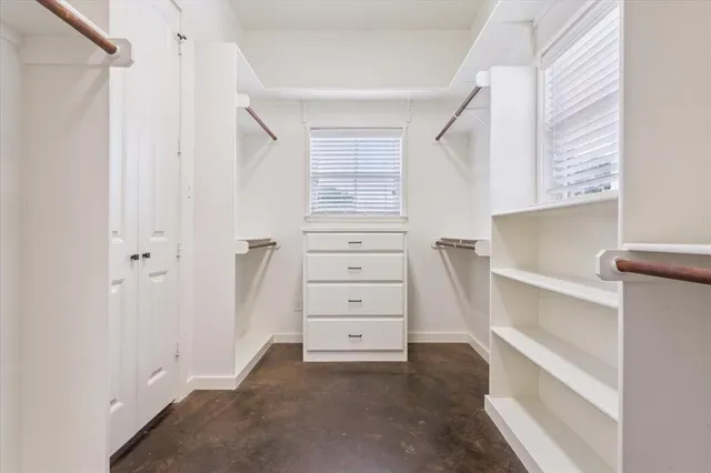 a view of walk in closet with empty racks