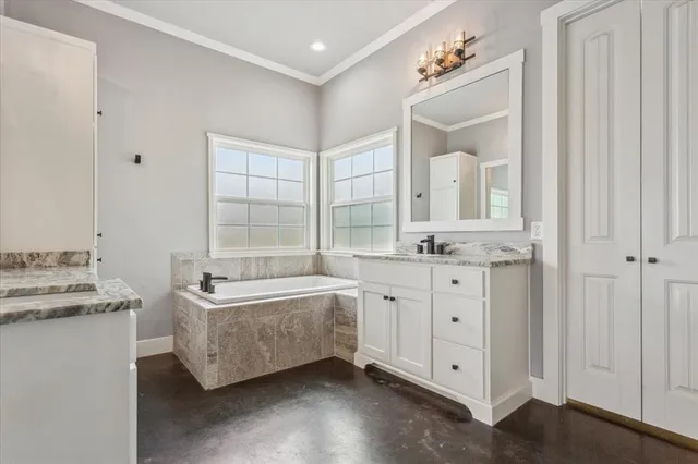 a spacious bathroom with a double vanity sink a mirror and a bathtub