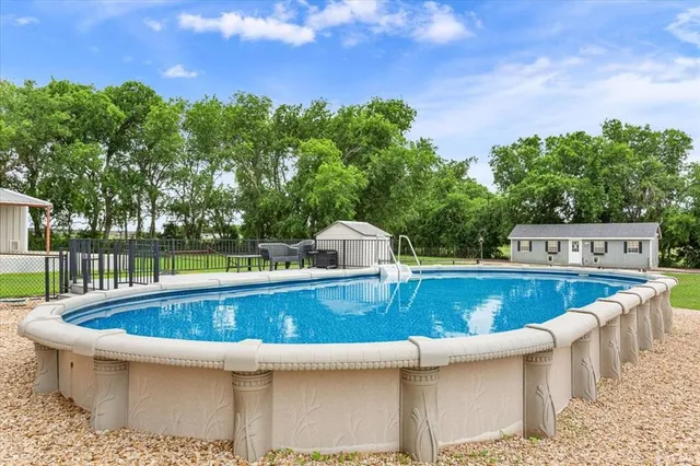 a view of a swimming pool with a yard and sitting area