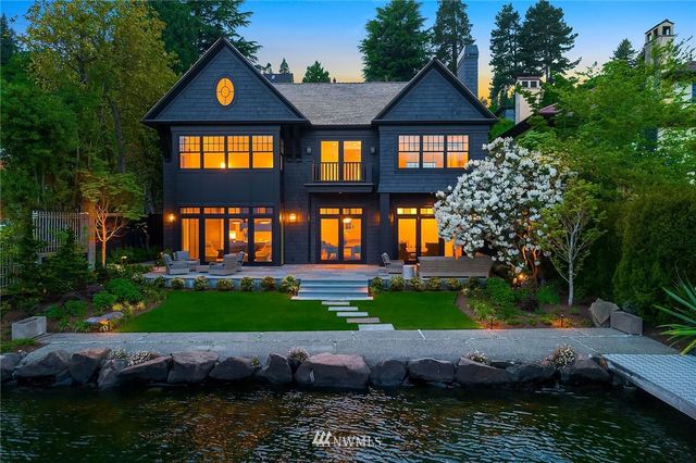 a front view of a house with a yard and potted plants