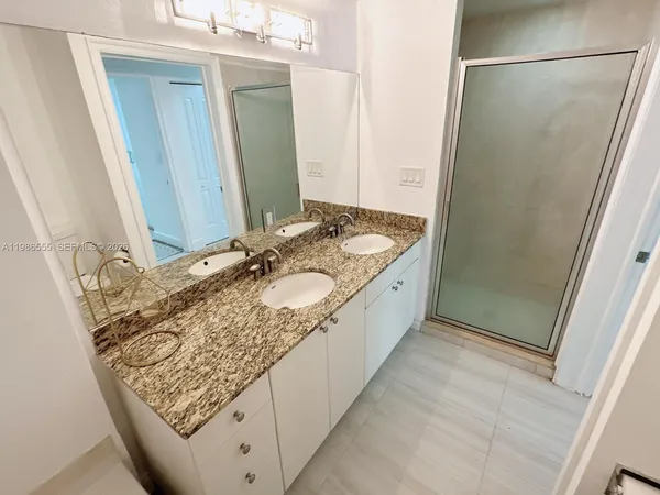 a bathroom with a granite countertop sink and a mirror
