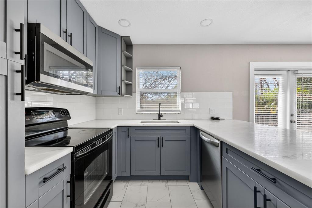 2714 West Grace Street Tampa, FL 33607 - Photo 12 of 26 a kitchen with stainless steel appliances a sink stove and cabinets
