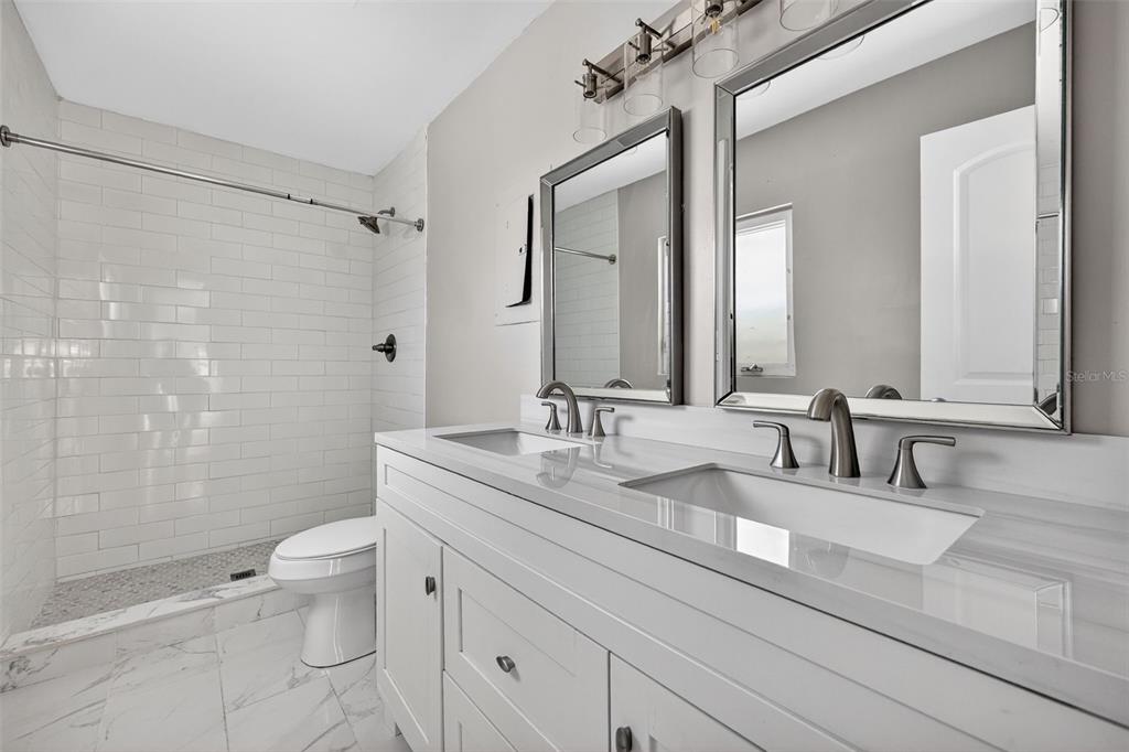2714 West Grace Street Tampa, FL 33607 - Photo 15 of 26 a bathroom with a double vanity sink toilet and shower