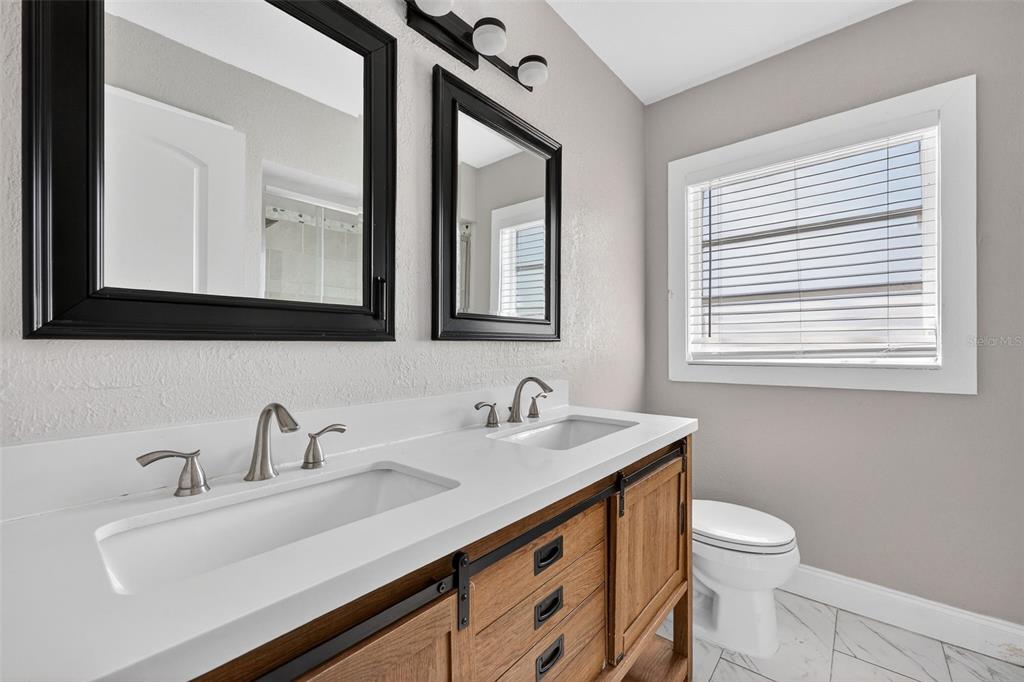 2714 West Grace Street Tampa, FL 33607 - Photo 16 of 26 a bathroom with a toilet sink and mirror