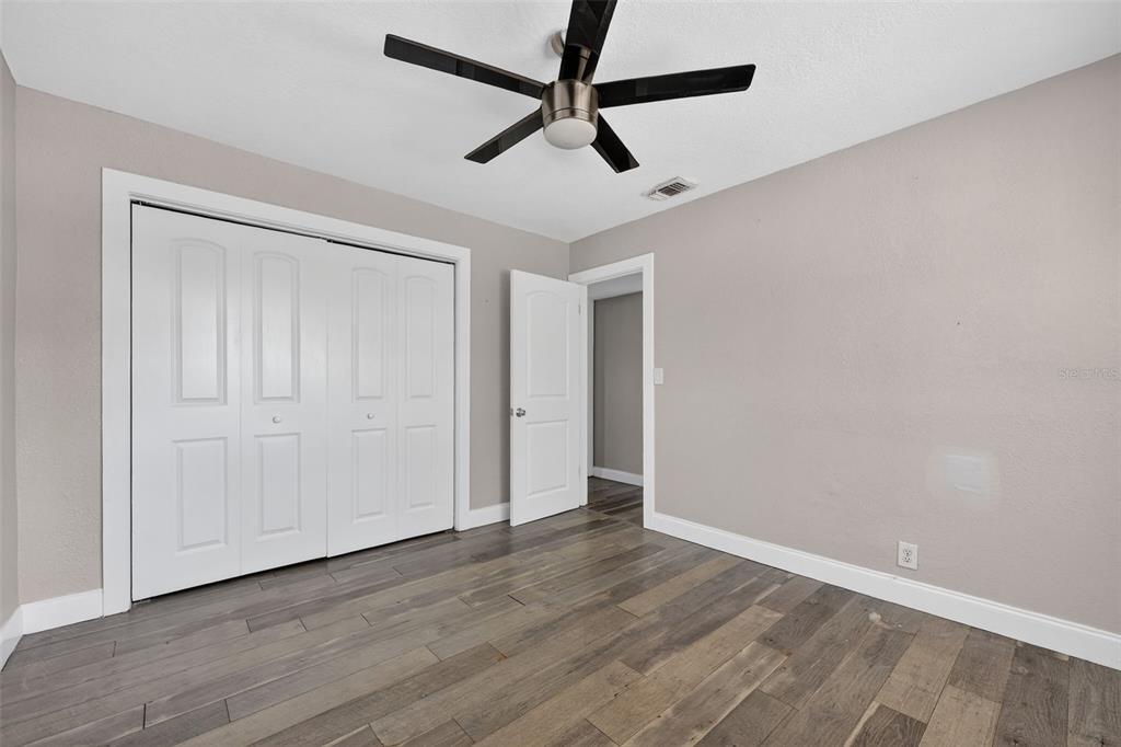 2714 West Grace Street Tampa, FL 33607 - Photo 19 of 26 an empty room with wooden floor ceiling fan and window