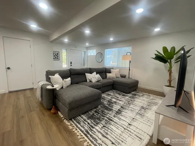 a living room with furniture a couch and a potted plant
