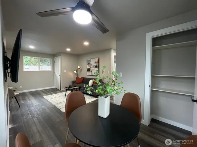 a dining room with furniture and a potted plant