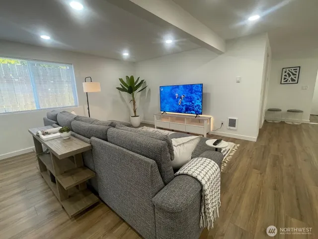 a living room with furniture and a wooden floor