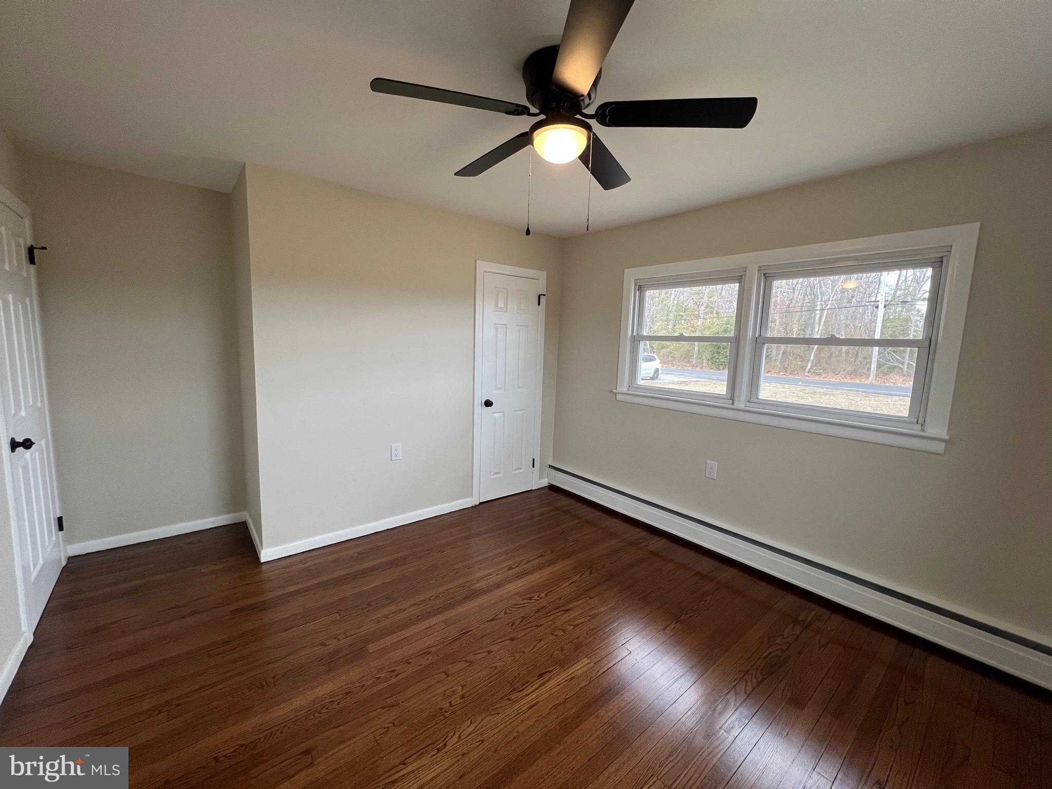 1086 Elk Road Monroeville, NJ 08343 - Photo 11 of 23 an empty room with wooden floor fan and windows