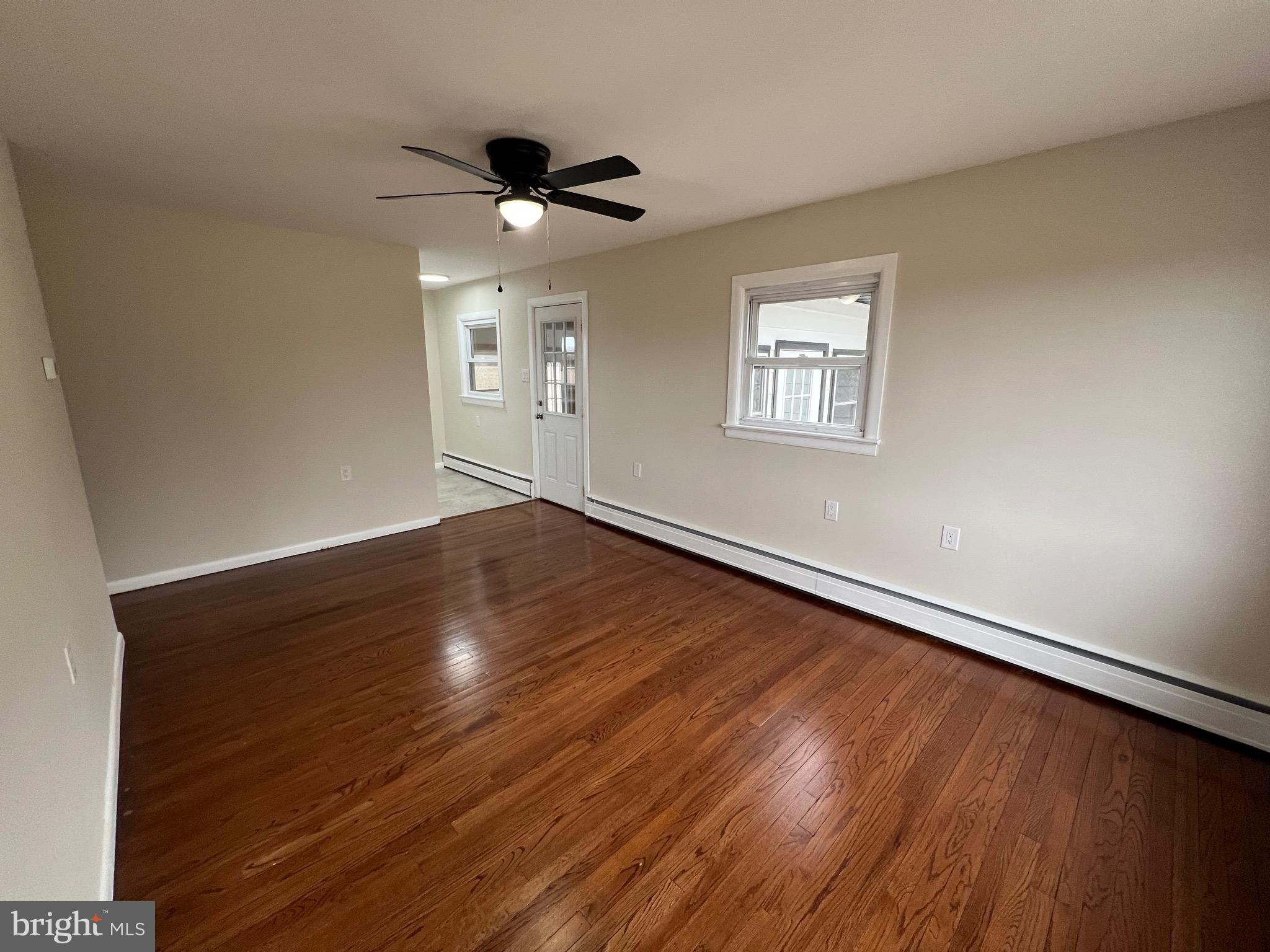 1086 Elk Road Monroeville, NJ 08343 - Photo 3 of 23 a view of an empty room with wooden floor and a ceiling fan