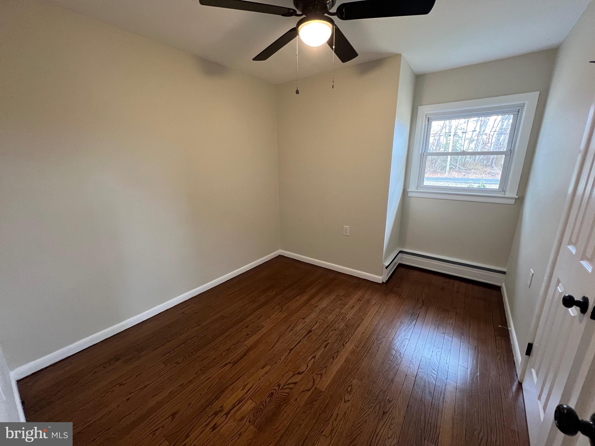 1086 Elk Road Monroeville, NJ 08343 - Photo 8 of 23 an empty room with wooden floor fan and windows