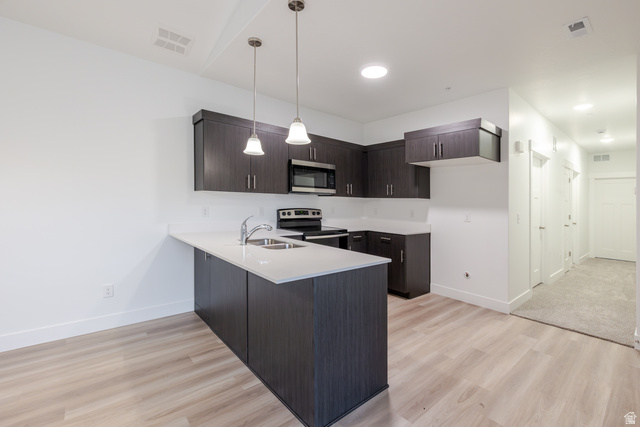 4661 Poplar Way, Unit R303 Mapleton, UT 84664 - Photo 12 of 17 Kitchen featuring dark wood finish cabinetry, a peninsula, stainless steel appliances, and light wood finished floors