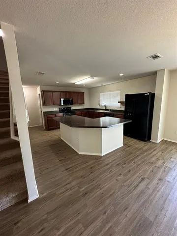 a view of kitchen with refrigerator microwave and stove