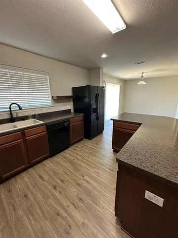a kitchen with stainless steel appliances granite countertop a sink dishwasher stove and refrigerator