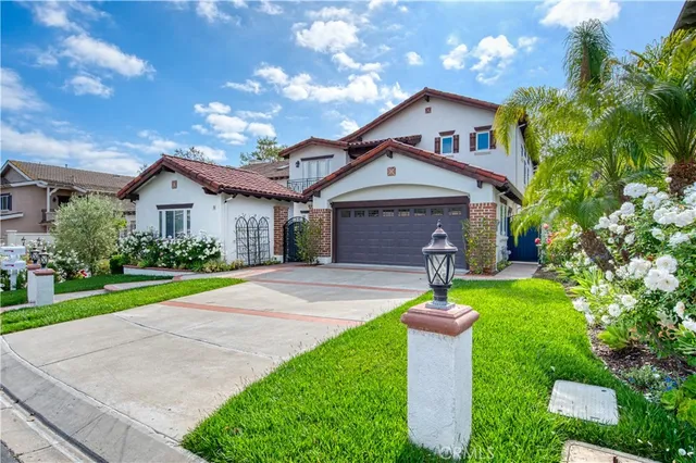a front view of a house with a yard and fountain