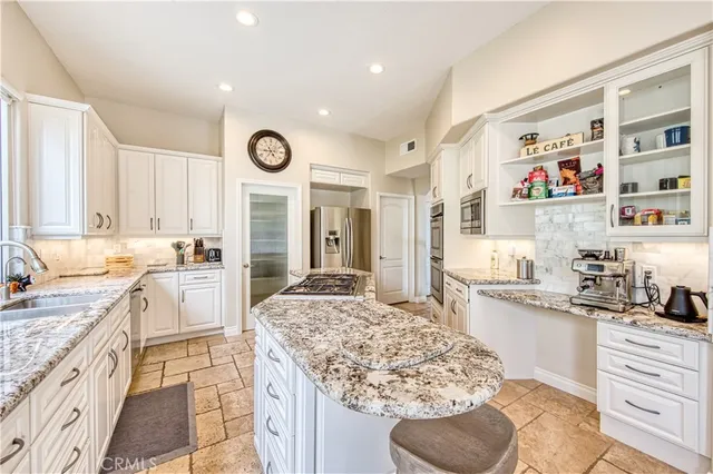 a large kitchen with granite countertop a sink and a stove top oven