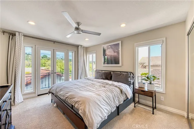 a bed sitting in a spacious bedroom next to a window