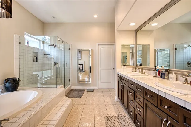 a spacious bathroom with a double vanity sink a mirror and a shower