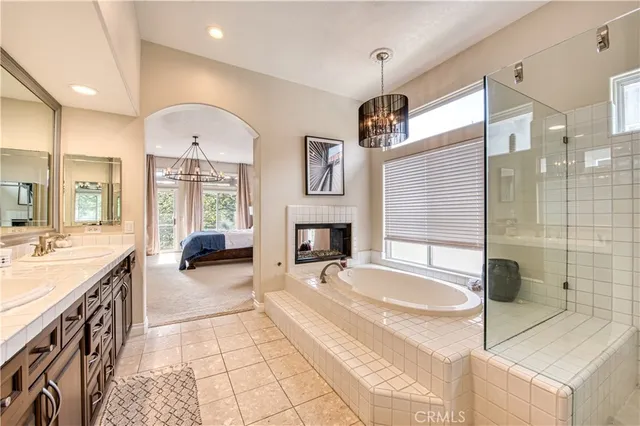 a spacious bathroom with a tub sink and mirror
