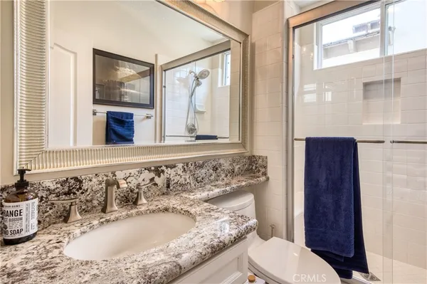 a bathroom with a sink a toilet and a mirror