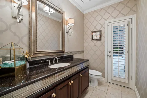 a bathroom with a granite countertop sink a toilet and a mirror