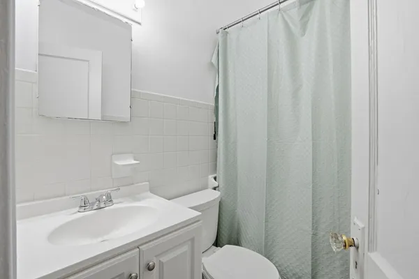 a bathroom with a sink a toilet and shower curtain