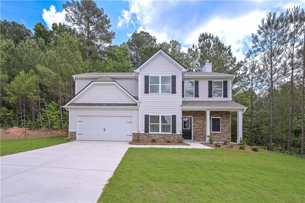 a front view of a house with a garden and yard