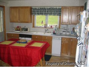 4 Point Rd Lake Factoryville, PA 18419 - Photo 4 of 5 a kitchen with stainless steel appliances granite countertop a sink a stove and a refrigerator